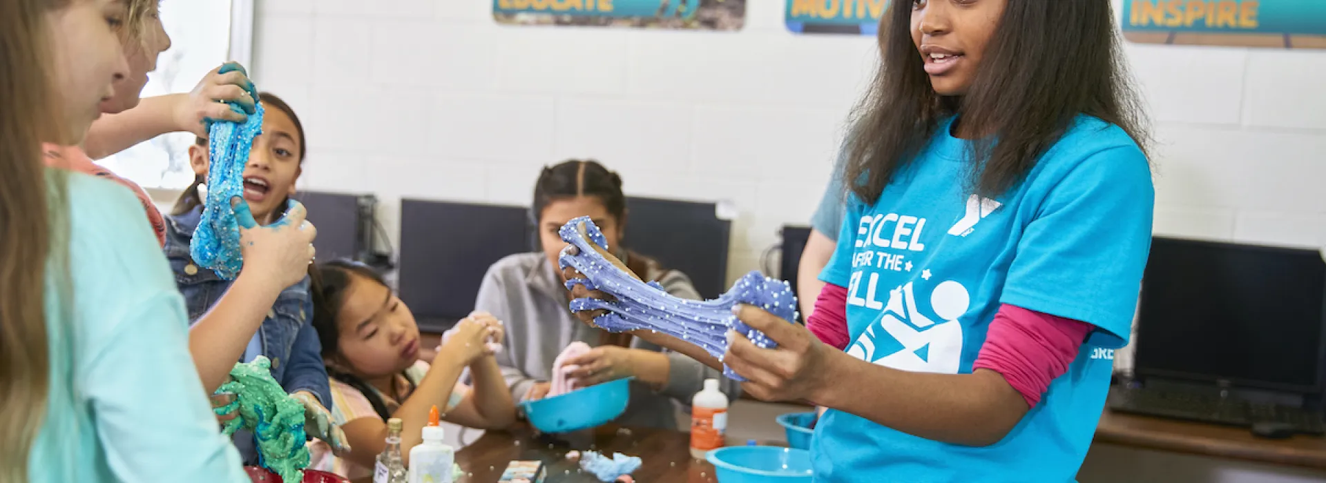 kids and y club staff have fun with a science experiement