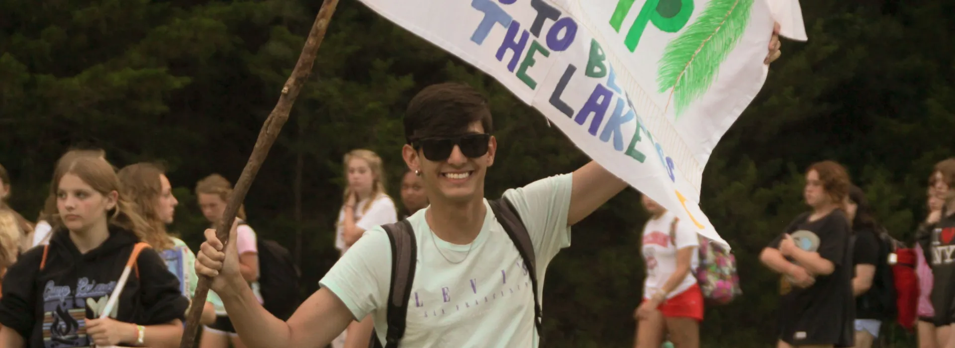 young man with flag at campfire
