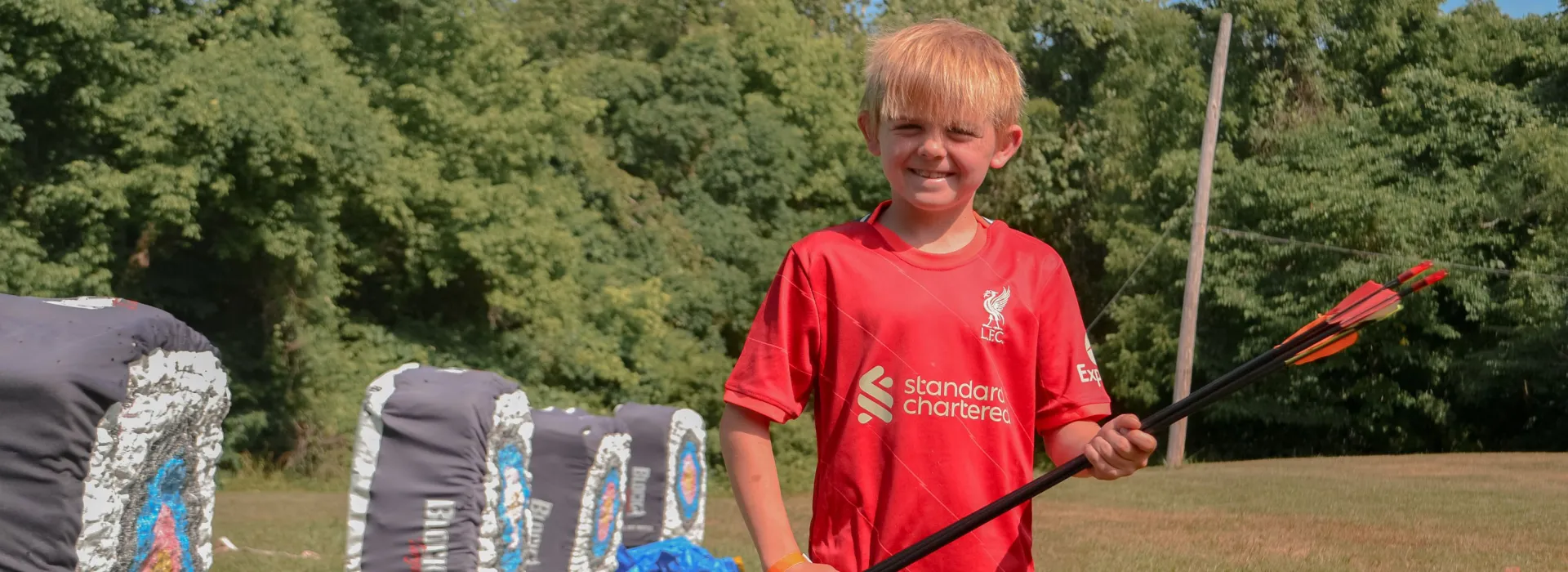 young boy retrieving his arrows at the archery range