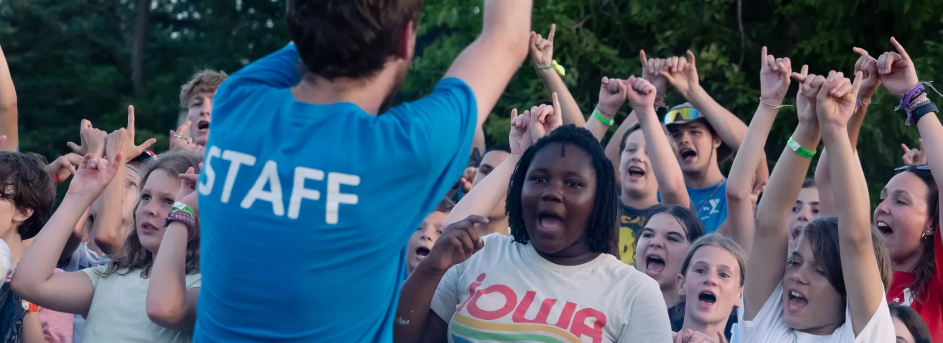 Counselor leading others at campfire