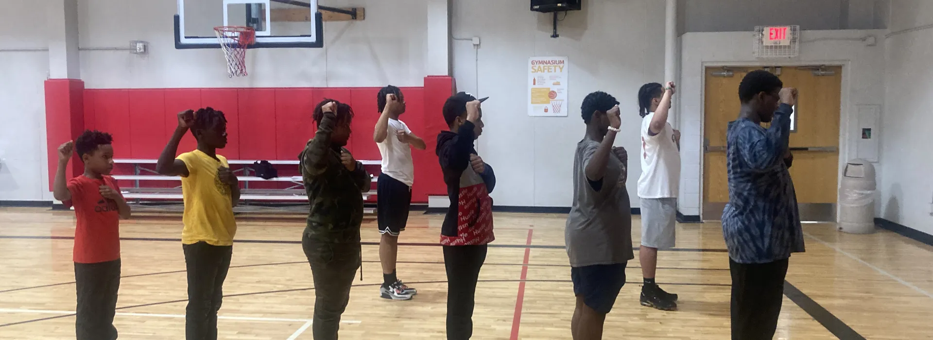 boys in BYMOC in the gym holding up their fists as a salute