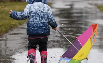 child playing in the rain
