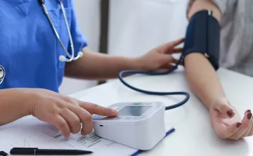 doctor taking patient's blood pressure